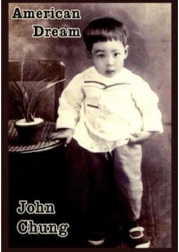 Vintage photo of a young boy dressed in old-fashioned clothes standing beside a gramophone.